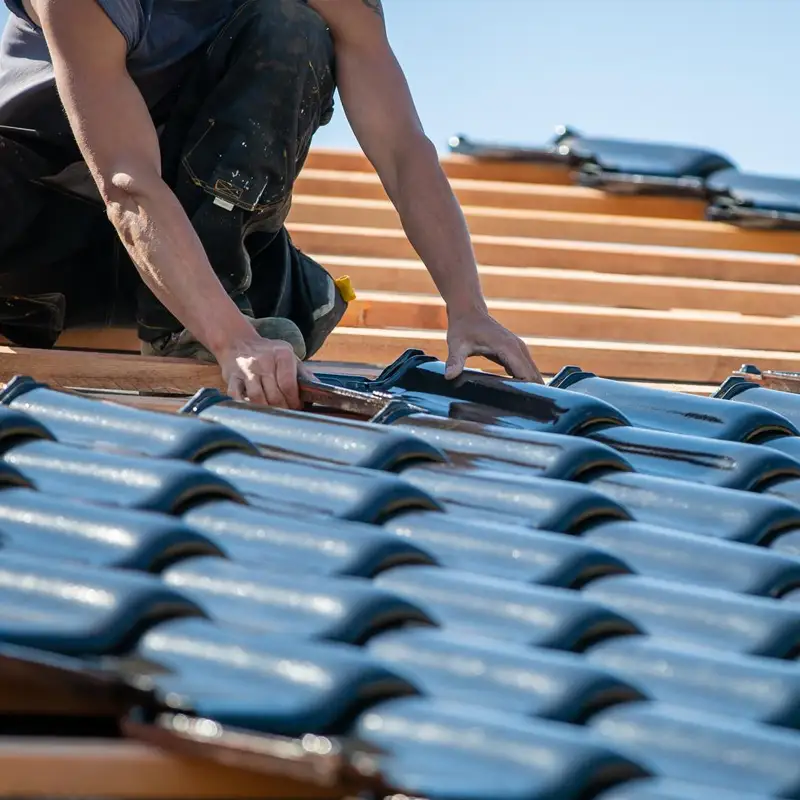 Couvreur effectuant un entretien sur une toiture en ardoise